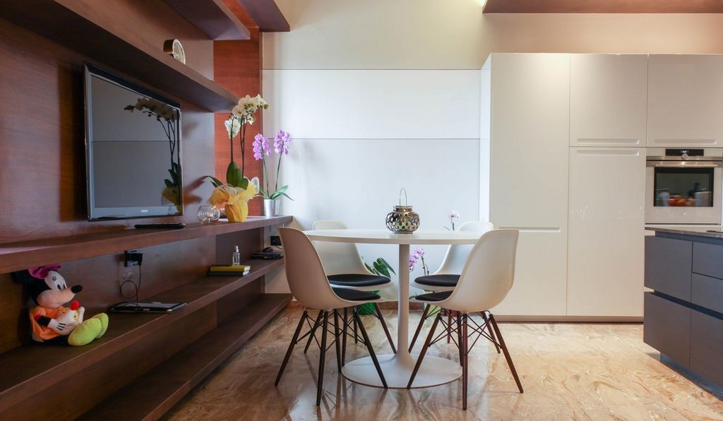 Tavolo cucina con sedute DSW e parete attrezzata con mensole su misura.